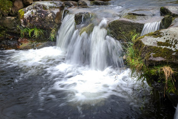 Fototapeta na wymiar Small waterfall tumbling over rocky edge