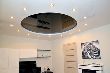  A living room fragment with a glossy stretch ceiling in black-and-white tones