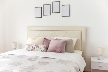 image of luxury bedroom double bed with pillows and image frames above.