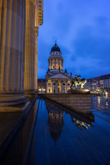 Naklejka premium Illuminated Konzerthaus Berlin (Berlin Concert Hall) and Französischer Dom (French Cathedral) at the Gendarmenmarkt Square in Berlin, Germany, in the evening.