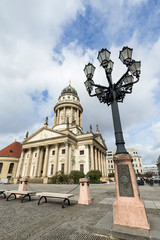 Old streetlight and Französischer Dom (French Cathedral) at the Gendarmenmarkt Square in Berlin, Germany, at day.