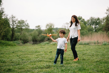 Stilish mother and handsome son having fun on the nature. Happy family concept. Beauty nature scene with family outdoor lifestyle. Happy family resting together. Happiness in family life. Mothers day.