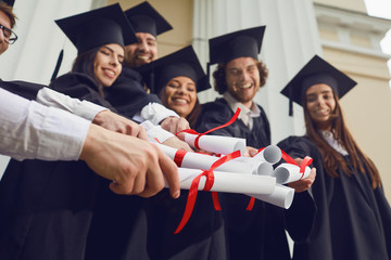 Scrolls in the hands of graduates.