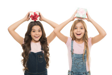 Learned how to gift wrap. Happy little girls holding gift boxes over head. Small children with gift packs on boxing day. Adorable kids with beautifully wrapped birthday gift boxes