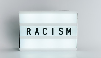 Light box with the headline RACISM with copyspace, over white background