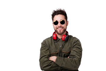 Obraz premium Photo of young bearded guy with sunglasses and headphones, standing with crossed hands over white wall