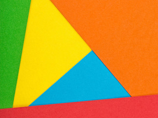 Color papers geometry flat composition background with yellow, green, orange, red and blue tones.