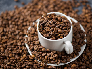 White Cup of coffee with coffee beans . Scattered coffee beans