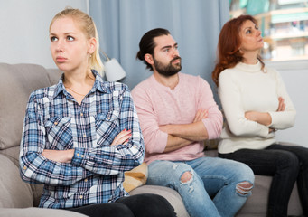 Young spouses and mother-in-low arguing indoors