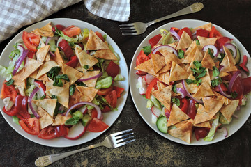 Bright healthy salad with vegetables and pita bread. Fattush Salad.
