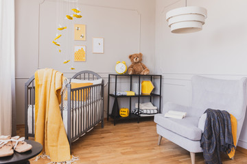 Teddy bear in a child room interior decorated with yellow bees