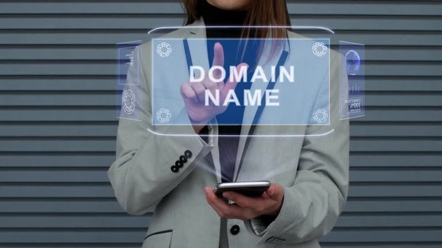 Unrecognizable business woman, interacts with a HUD hologram with text Domain name. Girl in a business suit uses the technology of the future mobile screen against the background of a striped wall