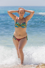 Overweight female person resting at the sea