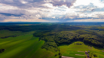 Fototapeta na wymiar flying over the forest, field, clouds and sky aerial nature