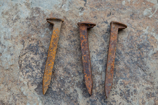 Rusty railroad spikes on granite background