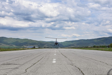 Small helicopter - tandem autogyro - taking off from a long wide tarmac runway, Sapareva Banya...