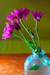 Closeup of Spring Flowers In Blue Glass Bottle On Polished Table With Copyspace.