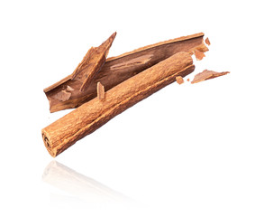 Cinnamon sticks crushed in the air closeup isolated on white background