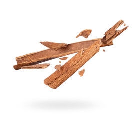 Cinnamon sticks crushed in the air closeup on white background