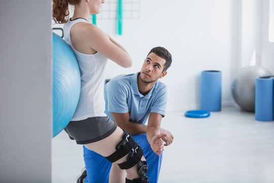 Professional personal trainer and sportswoman exercising with ball