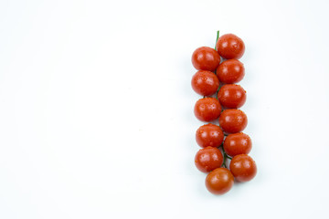 A branch of fresh red tomatoes with water drops isolated on white background Food and drinks Agriculture
