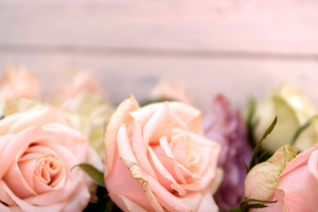 Pink roses on the wooden desk. Flat lay rose flower with leaves frame.