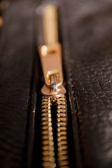 Detail of zipper on black leather. Macro with extremely shallow depth of field.