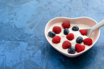Morning Breakfast Yogurt with Berries Top View. Serving of Organic Sweet Dairy with Raspberries and Blackberries in Form of Heart Ceramic Bowl and Spoon. Healthcare Vegetarian Nourishment