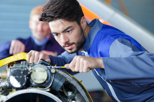 Checking Airplane Engine In Airport Hangar