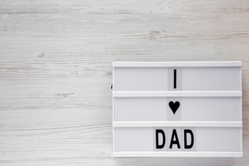 'I love dad' words on a modern board over white wooden background, top view. Overhead, from above, flat lay.