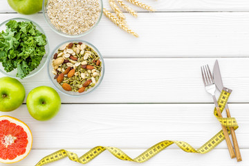 Diet for weight loss concept with measuring tape, greenary and oat on white background top view copy space