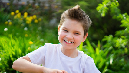 child smiling, enjoying vacation. portrait of young boy in nature, park or outdoors. concept of happy childhood.