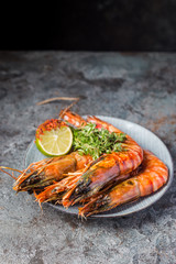 Giant fresh Tiger Prawns on plate over dark stone background