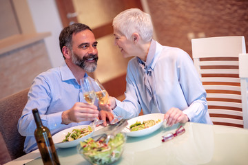Romantic mature couple enjoying  lunch at home