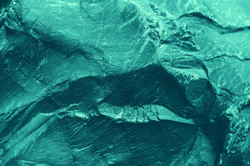 Vintage azure background. Rough painted wall of turquoise color. Imperfect plane of cyan colored. Uneven old decorative toned backdrop of aqzure tint. Texture of teal hue. Ornamental stony surface.