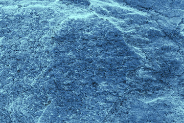 Vintage blue background. Rough painted wall of sapphire color. Imperfect plane of blue colored. Uneven old decorative toned backdrop of cyan tint. Texture of sapphirine hue. Ornamental stony surface.