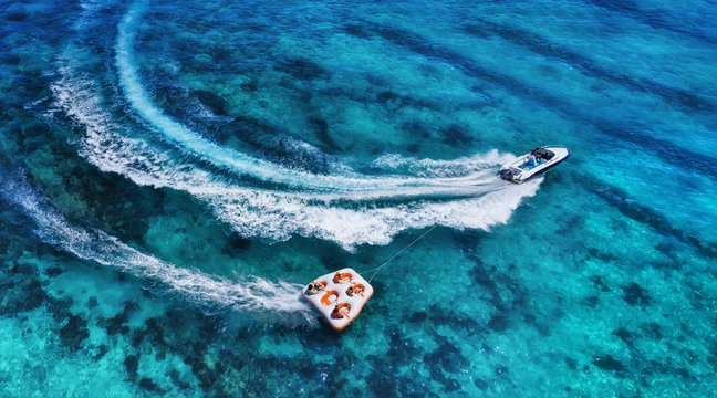 Yachts at the sea surface. Aerial panoramic view of luxury floating boat on transparent turquoise water at sunny day. Top view from drone. Seascape with motorboat in bay. Travel - image