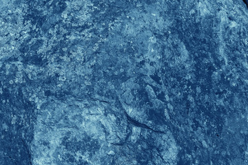Vintage blue background. Rough painted wall of sapphire color. Imperfect plane of blue colored. Uneven old decorative toned backdrop of cyan tint. Texture of sapphirine hue. Ornamental stony surface.