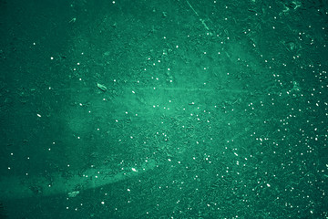 Vintage green background. Rough painted wall of emerald color. Imperfect plane of virid colored. Uneven old decorative toned backdrop of green tint. Texture of emerald hue. Ornamental stony surface.