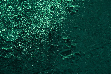 Vintage green background. Rough painted wall of emerald color. Imperfect plane of virid colored. Uneven old decorative toned backdrop of green tint. Texture of emerald hue. Ornamental stony surface.