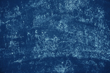 Vintage blue background. Rough painted wall of sapphire color. Imperfect plane of blue colored....