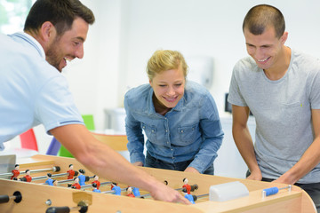 three young people playing table football