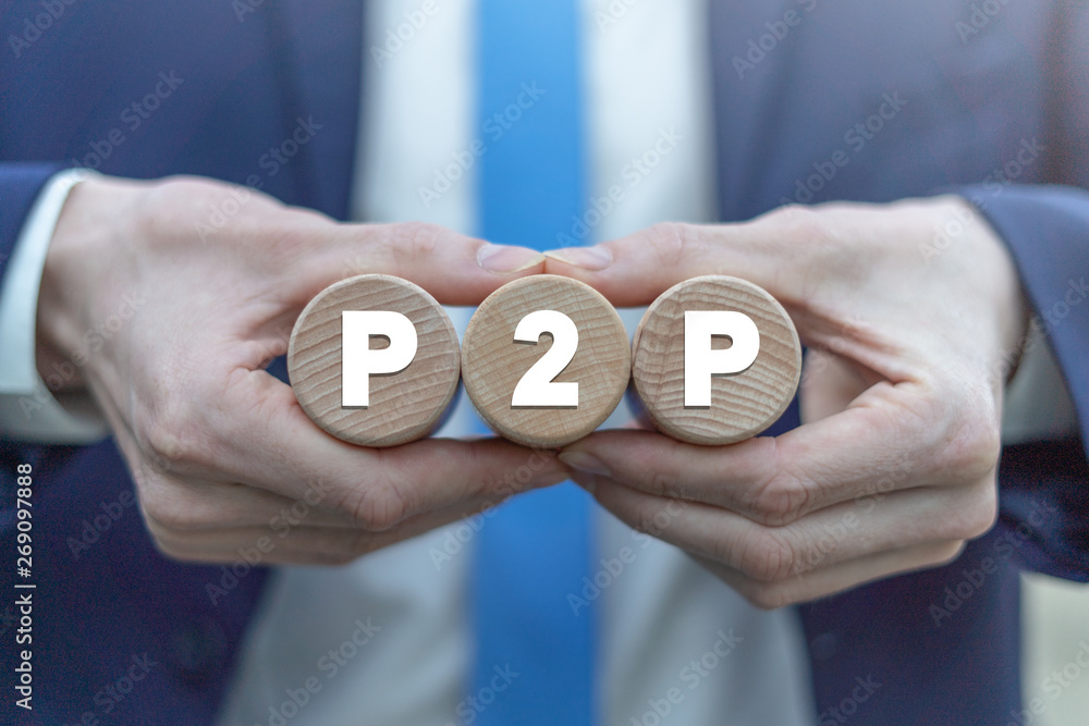 Poster p2p peer to peer technology web network business concept on a wooden cylinders in a businessman hand