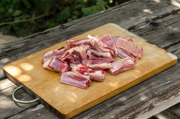 Chopped lamb ribs for making pilaf on a wooden board