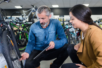 Fototapeta na wymiar positive man reviewing bicycles at bike store