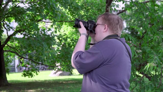 Young man takes pictures in the park
