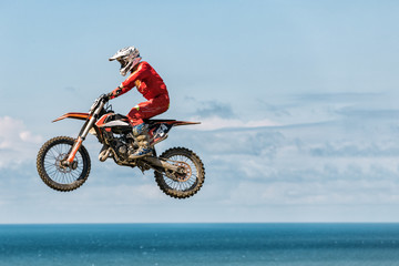 Fototapeta na wymiar A picture of a biker making a stunt and jumps in the air