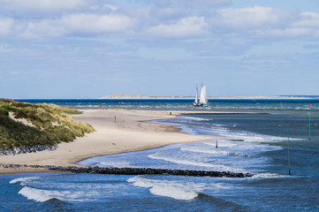 North sea seascape of seaside on Vlieland island with ground swell blue sea and big sailing vessel...