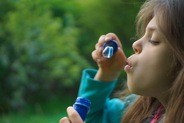 the child makes soap balloons