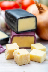 Mini black and dark red waxed cheddar cheeses with strong flavor made from West Country milk and and age-old methods with onion and garlic in England